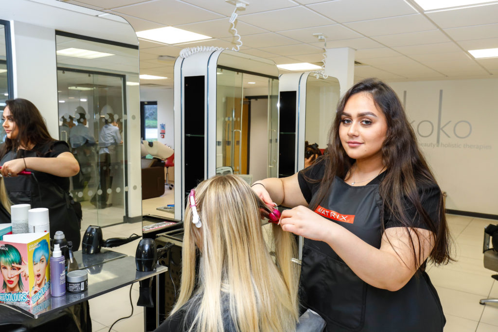 Badriya Albaloushi, a hairdressing student brushes the hair of a woman in the Koko hair salon at Cornwall College Camborne