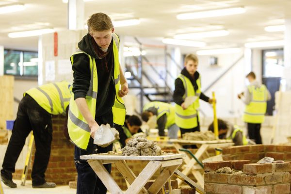 Bricklaying student using a trowel to build a wall at Cornwall College