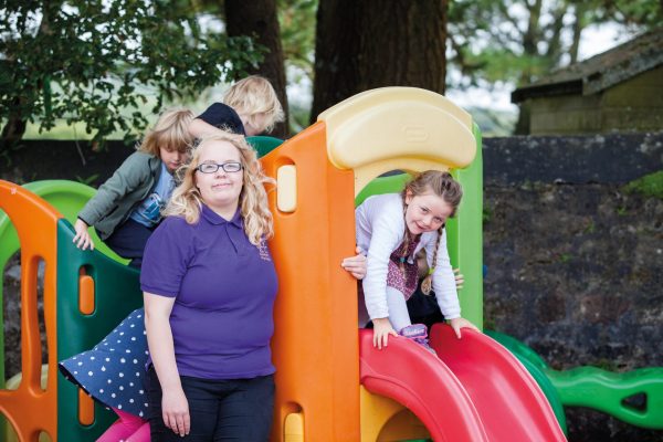 early years apprentice supervising small children in a park area