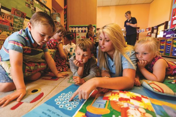 Early years student with a group of small children in a play setting at Cornwall College