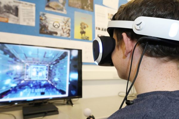 Games design student playing a game with VR headset on