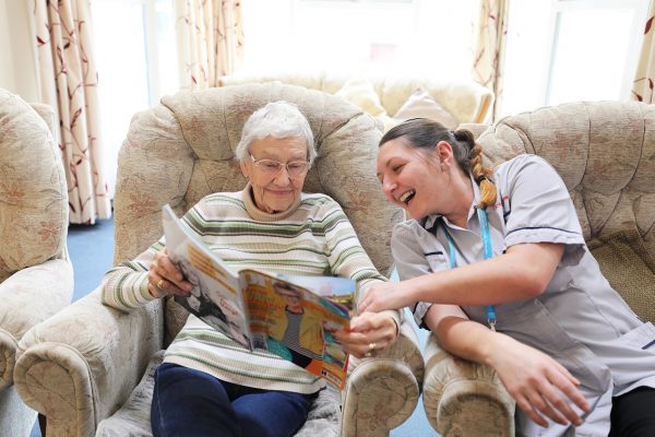 Healthcare assistant laughing with a client in a Cornwall Care home