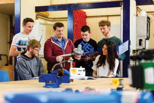 A group of students look at different kinds of heating pumps.