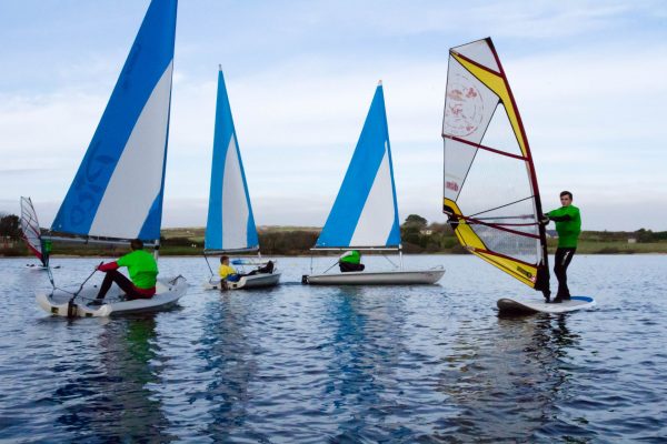 students windsurfing and sailing on a lake