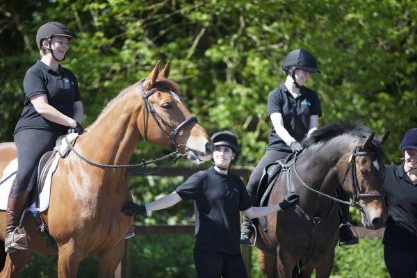 Students smiling and sitting on horseback talking