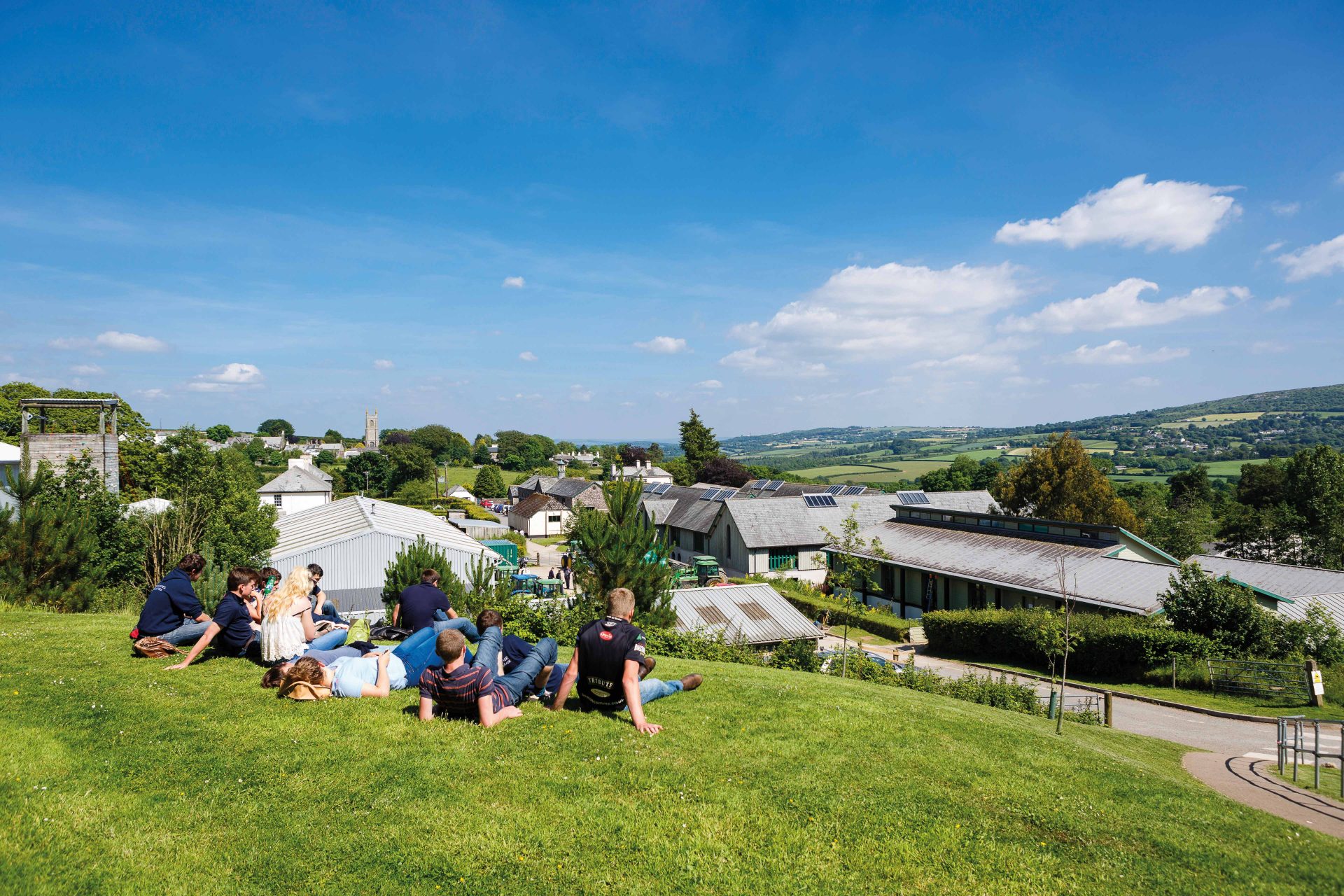 Students sitting on the grass at a sunny Stoke Climsland
