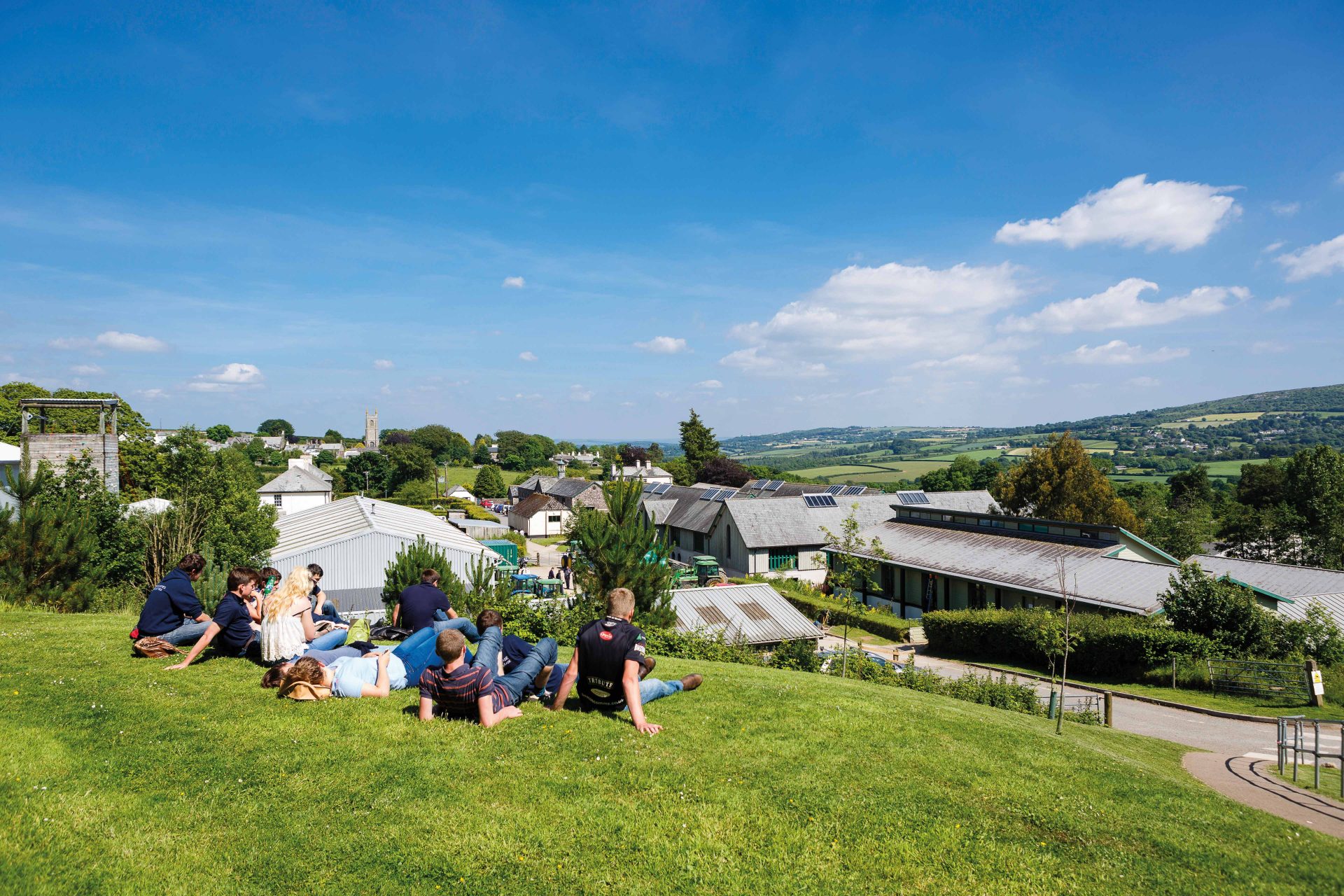 Students sitting on the grass at a sunny Stoke Climsland