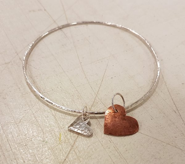 Silver bracelet with bronze and silver heart charms