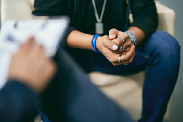 Closeup of a clients hands while they talk to a counsellor