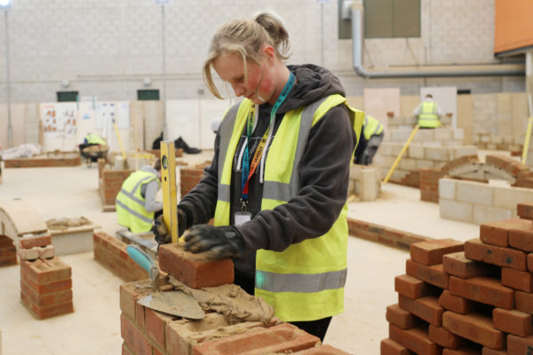 Student building a brick wall