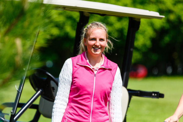 Golf student in front of a golf cart