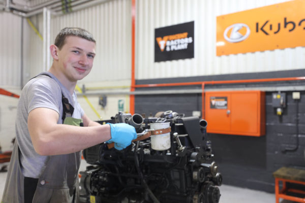 An engineering student working on an engine