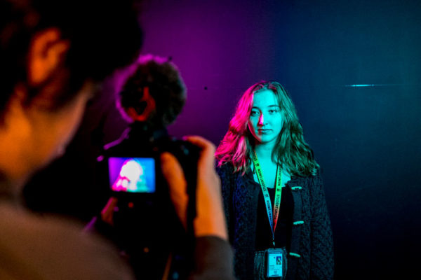 Arts and media students in a studio using filming equipment