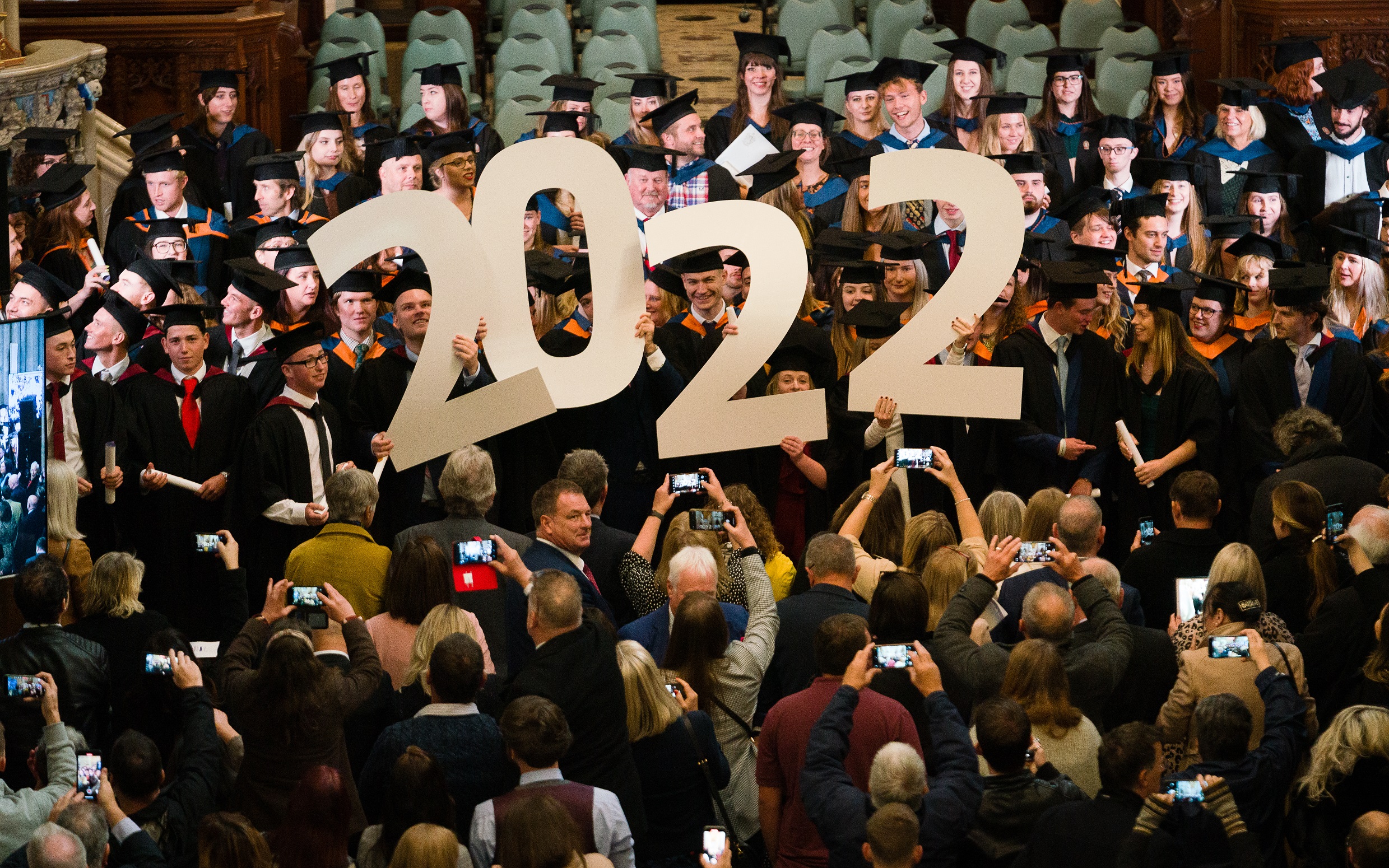Happy Graduates at Truro Cathedral holding a large cutout of the 2022 year numbers