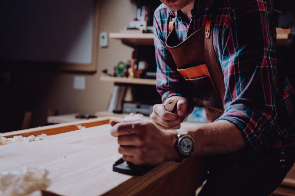 A carpenter using a plane