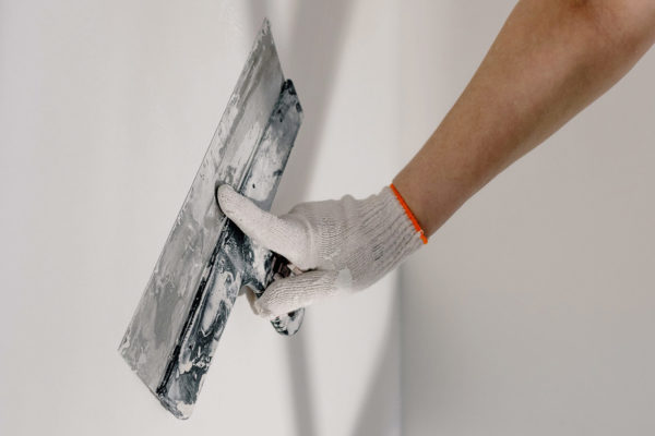 A close-up of someone plastering a wall