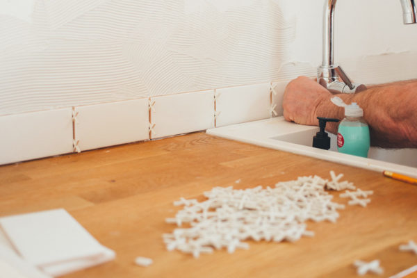 Someone tiling a kitchen