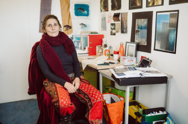 Student sitting in her work space facing the camera.