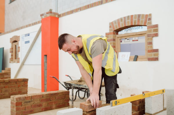 A student building a brick wall